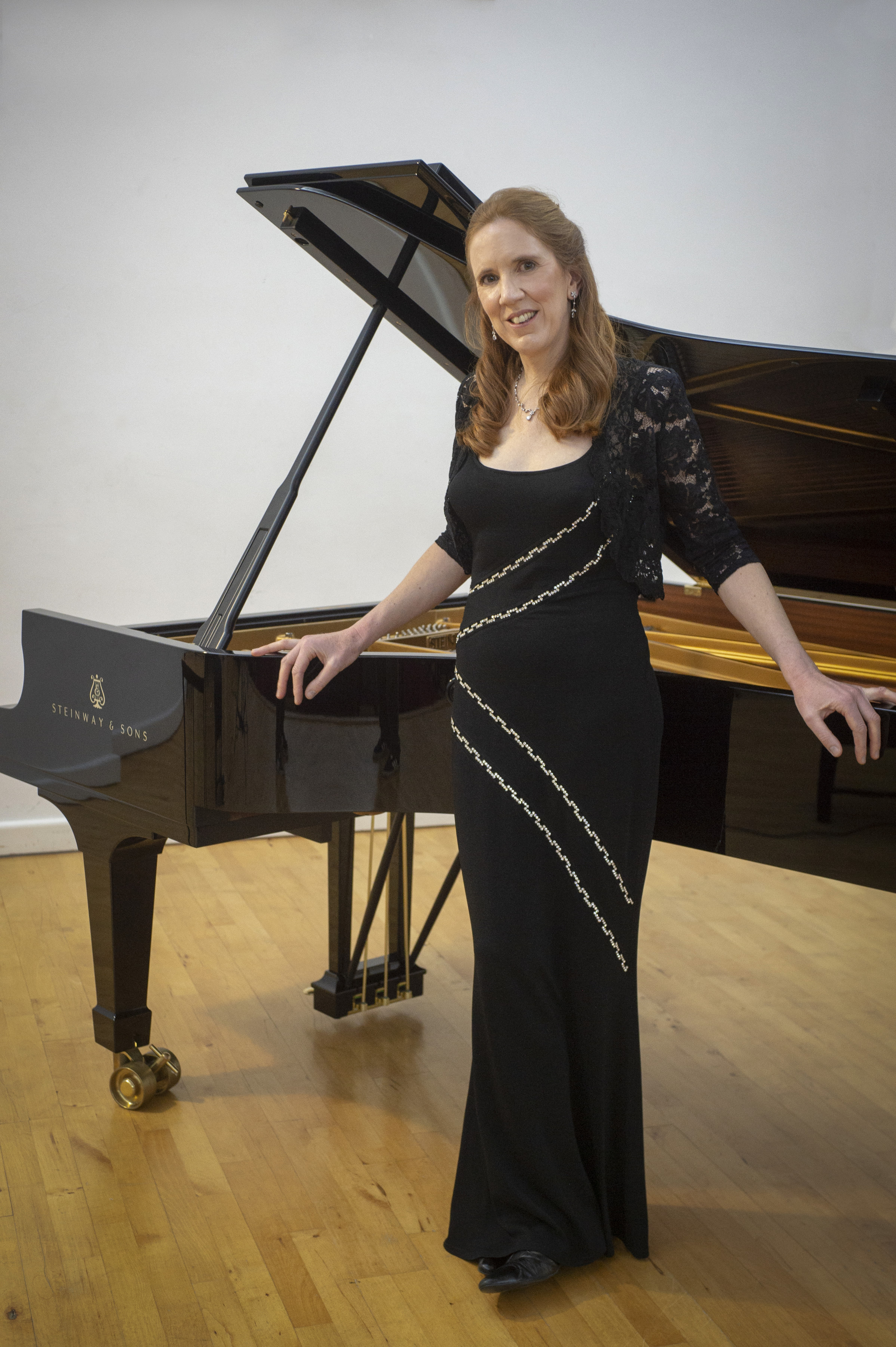 Sarah Beth Briggs standing at the piano