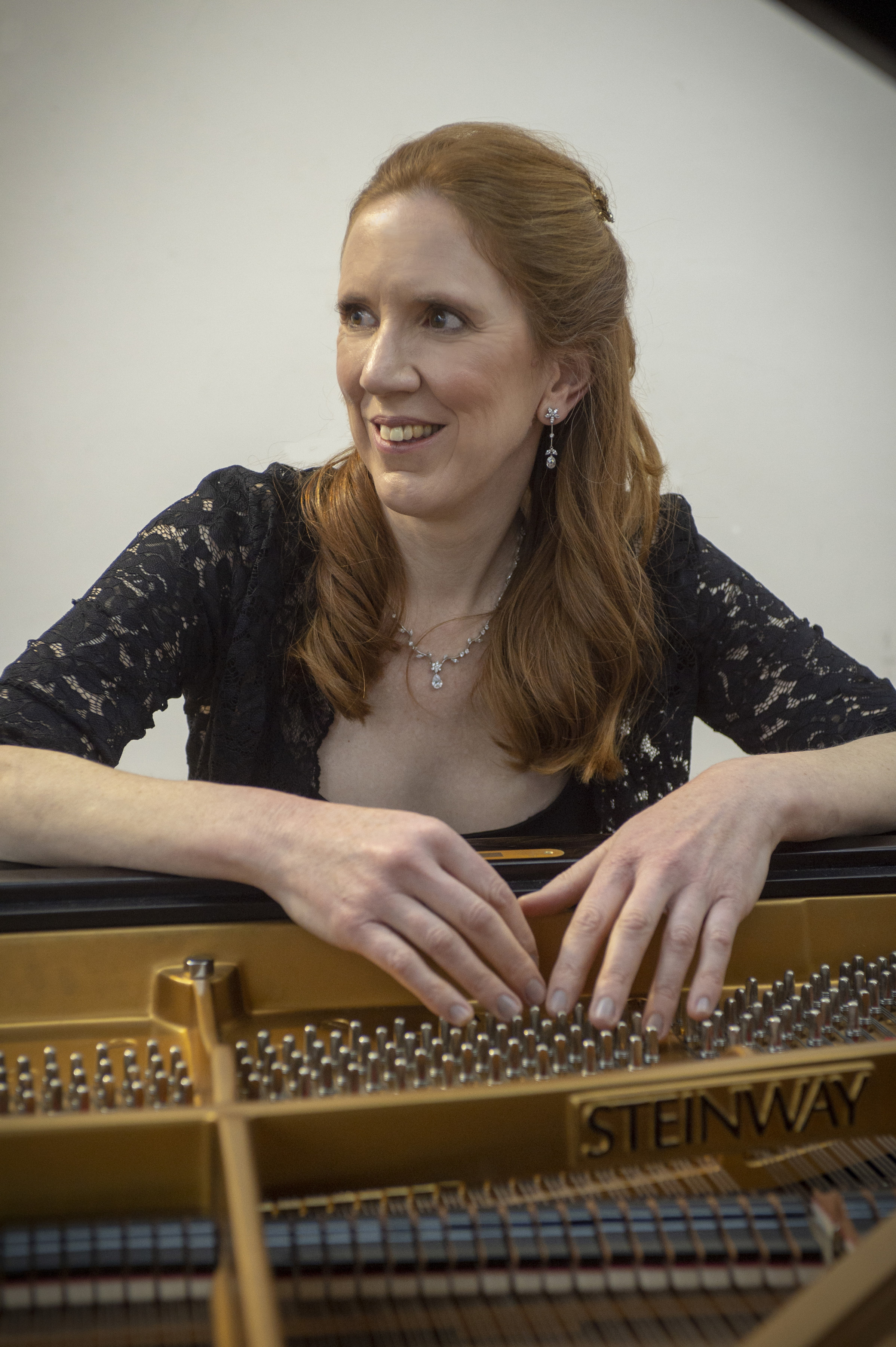Sarah Beth Briggs leaning on piano